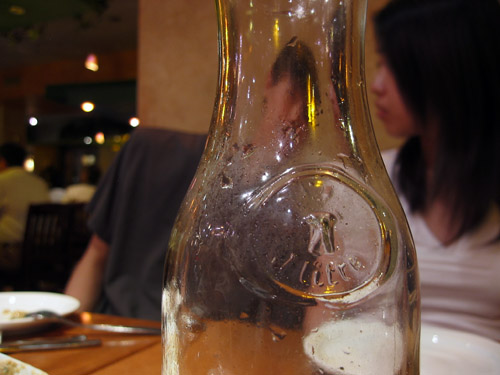 A glass bottle in Zaffron, Ju-lian and Pheth in the background.