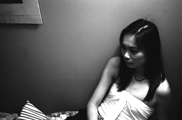 Liz sitting on Paolo's bed.
