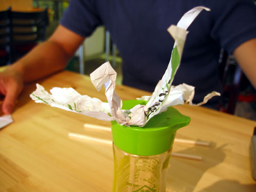 A bird made out of chopstick wrapers.