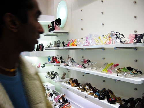 Ahilan standing next to a shelf of shoes in ready2wear.