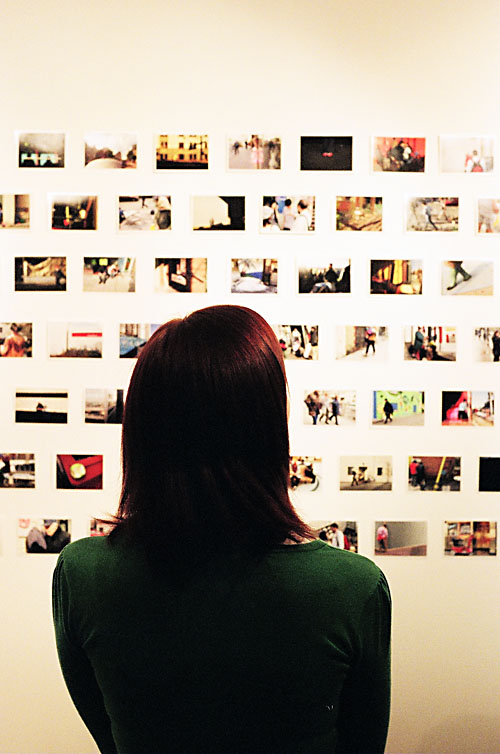 A girl looking at some photos at the PubliCITY exhibit.
