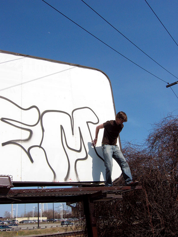 Tyler behind a billboard.