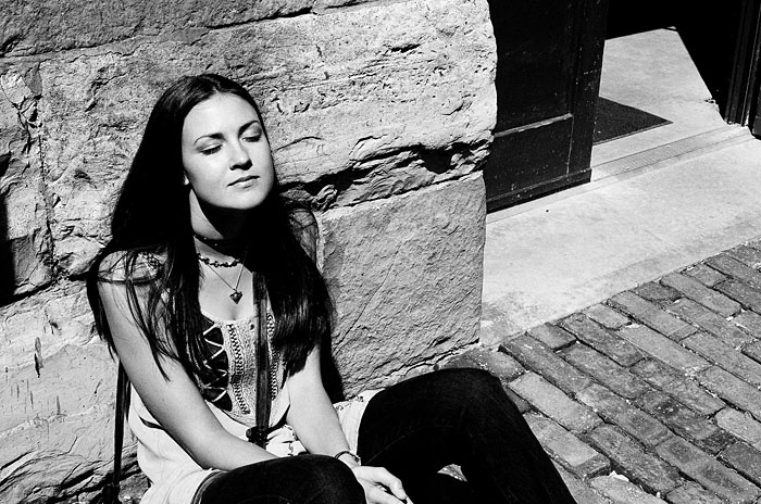 Caroline resting against a wall in the distillery district.