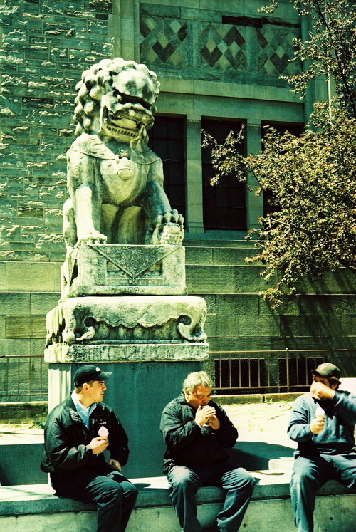 A group of guys eating ice cream in front of the ROM.