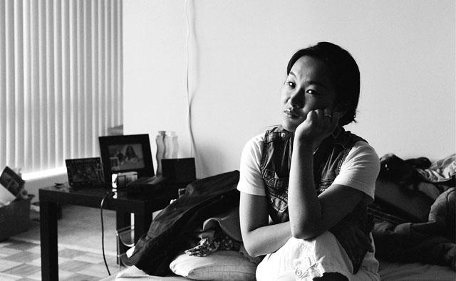 Minh sitting on my bed.