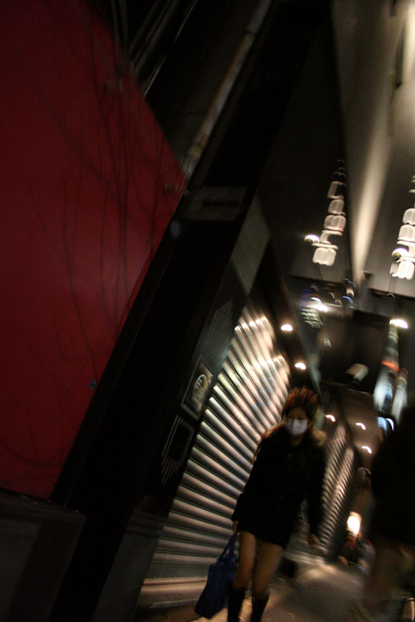 A young lady in Japan walking down a street in Roppongi Hills.